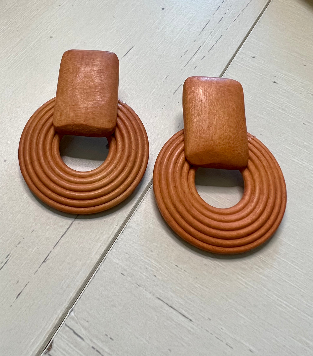 Wooden rectangular base and circle underneath earrings